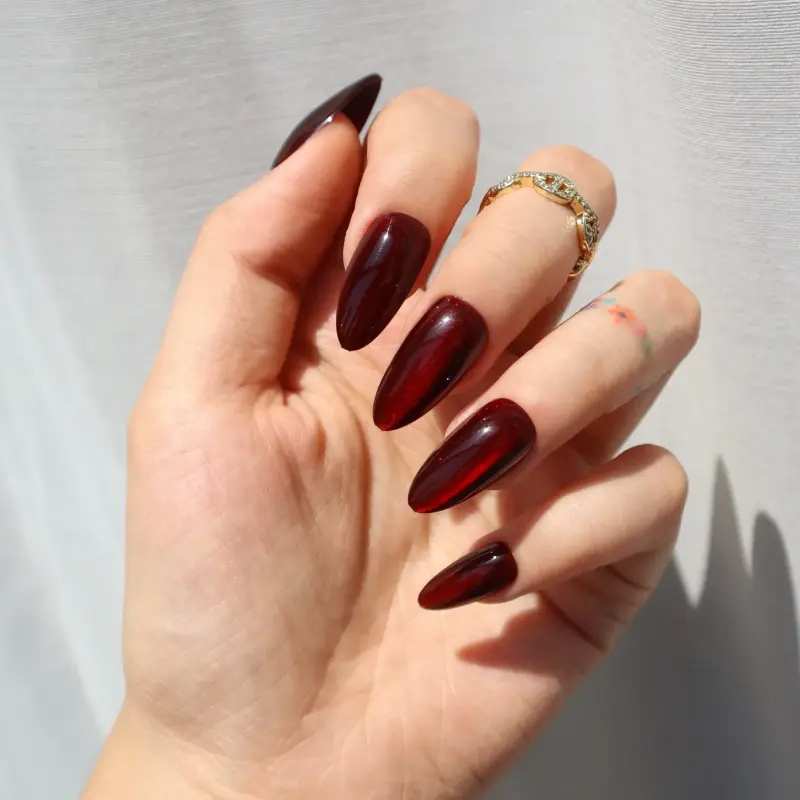 Манікюр насиченого кармінового кольору на нігтях чіткої форми, що символізує рішучість та енергію Венери в Овні