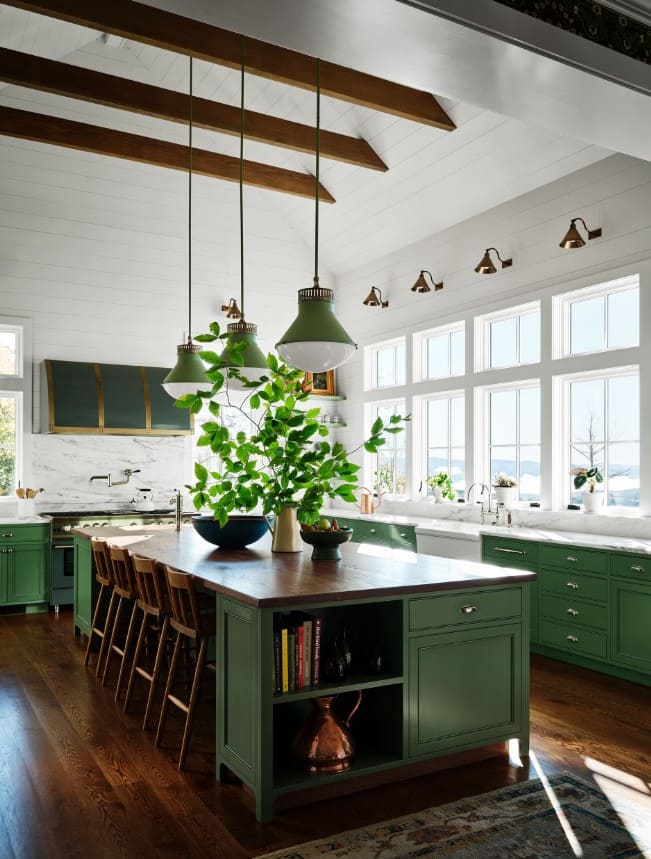 Простора кухня з темно-зеленими фасадами, масивним дерев'яним островом та відкритими стельовими балками