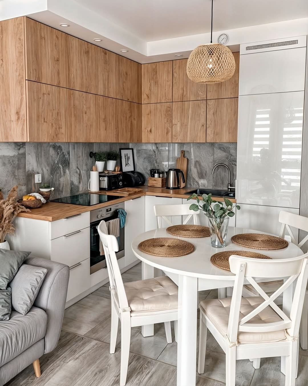 Сучасна кутова кухня: білі фасади, стільниця під дерево та сірий керамограніт