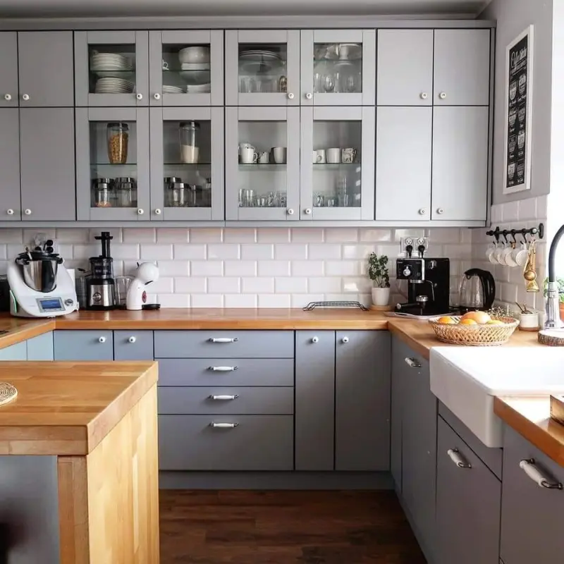 П-подібний кухонний гарнітур сірого кольору з дерев'яною робочою поверхнею та фартухом із білої плитки "кабанчик"