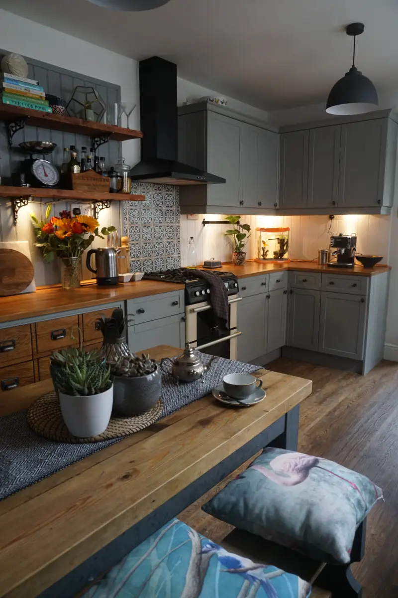 Сіра кухня з дерев’яною робочою поверхнею та відкритими навісними полицями для посуду 
