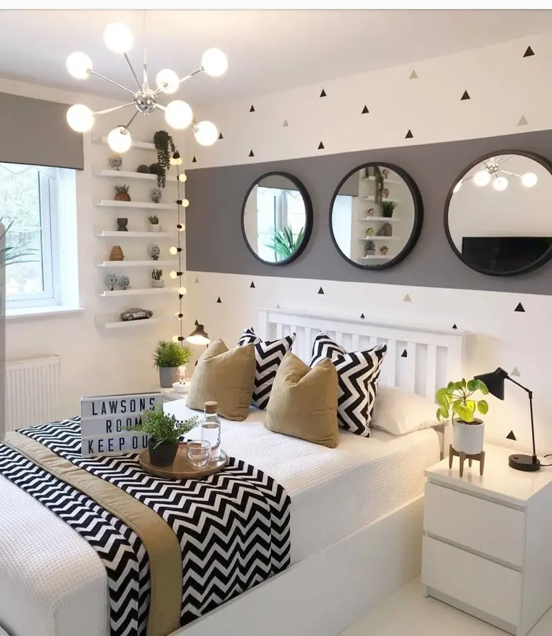 Спальня в нейтральних тонах з люстрою оригінальної форми, світильником у вигляді гірлянди та настільною лампою