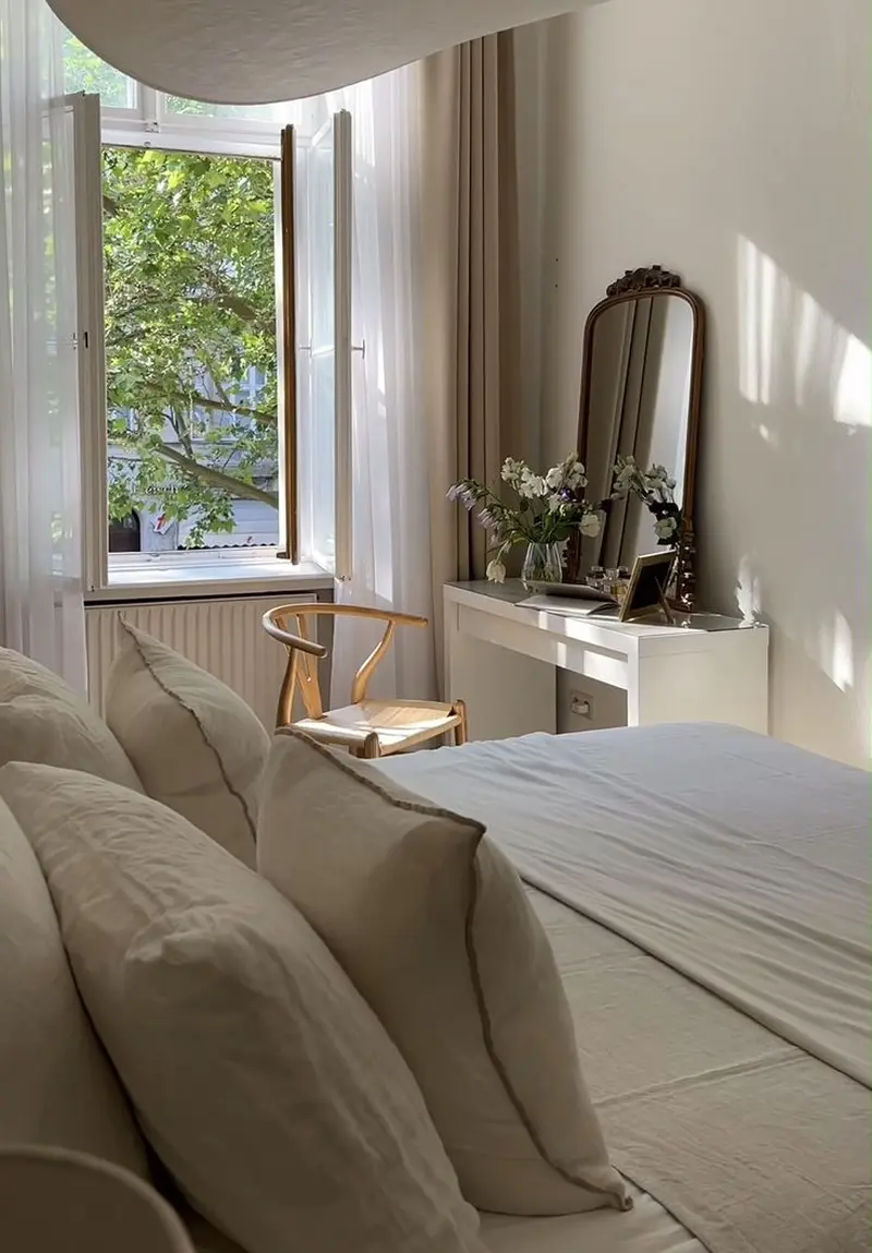 Компактний туалетний столик з дзеркалом та легким стільцем біля вікна