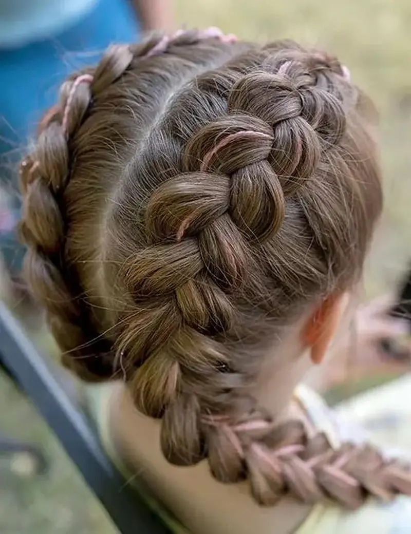 Дві пишні голландські коси на русявому волоссі, що створюють об’ємний рельєфний візерунок