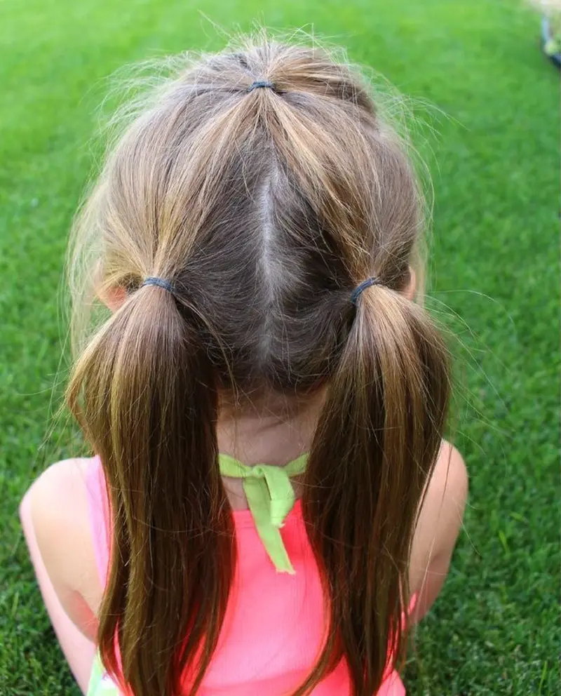 Два класичні низькі хвостики на прямий проділ та маленьке зібране пасмо на маківці